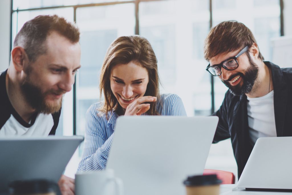 Tre kollegor som sitter vid sina datorer