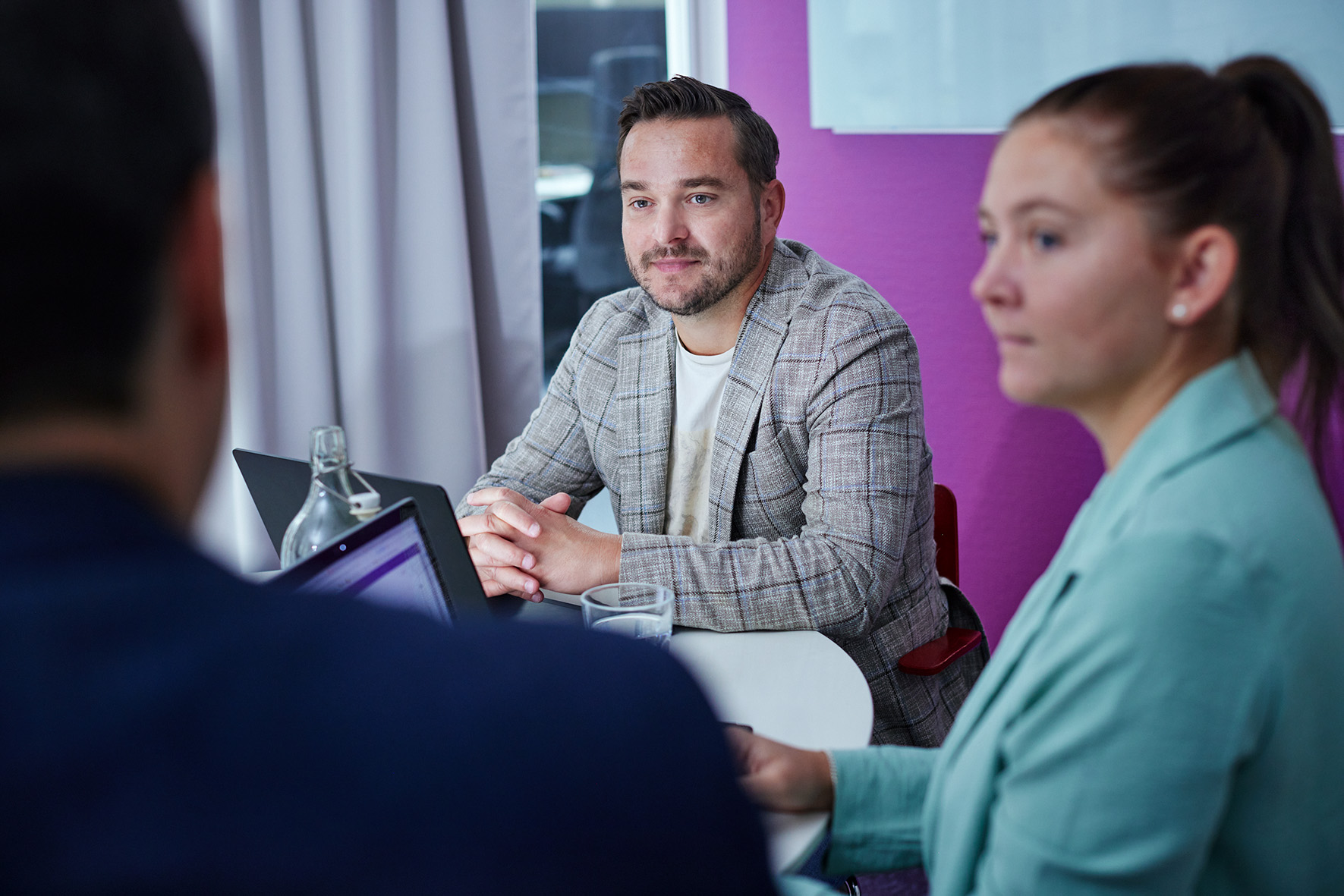 Två kollegor som sitter och lyssnar på ett möte