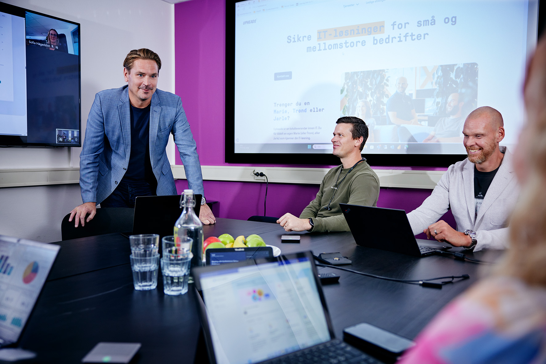 Kille står och håller i ett möte med sina kollegor